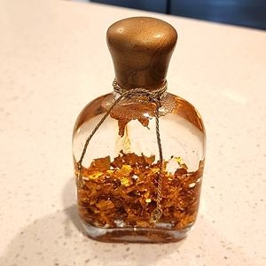 Glass bottle with gold gators in liquid